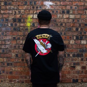 A man wearing a Dallas-themed T-shirt with the word “Texas” written in Japanese and a majestic eagle and sword design by a local artist.